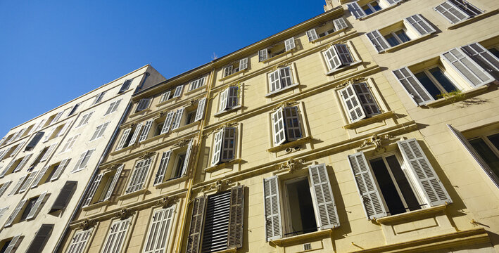 Classic facades creating a pattern under a bright blue sky in Marseille, France