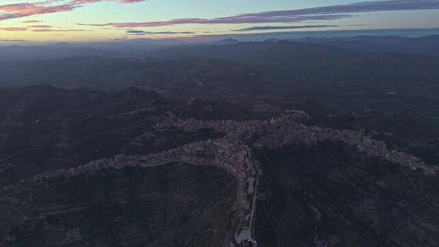 Aerial view of the historic town of Centuripe with its unique star-shaped layout illuminated by the soft light of sunset in Centuripe, Sicily, Italy.