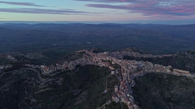 Aerial view of the historic town of Centuripe perched on a mountain ridge during golden hour in Centuripe, Sicily, Italy.