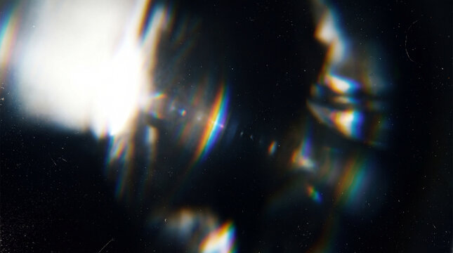 A high-quality abstract optical lens flare effect featuring rainbow chromatic aberrations and subtle vintage film grain on a dark background.