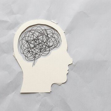 Paper Cutout Silhouette of a Human Head with Tangled Lines Representing a Confused or Overwhelmed Brain
