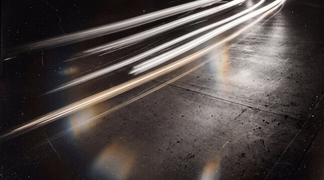 A long exposure shot capturing glowing motion blur light trails from vehicles moving across a dark asphalt road at night with vintage film texture effects.
