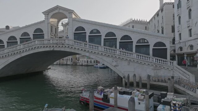 Aerial view of the historic Rialto Bridge spanning the Grand Canal with boats docked nearby in Venice, Veneto, Italy.