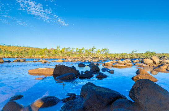 Stony foreground of scenic Penticost River in Western Australian outback in Kimberley Region