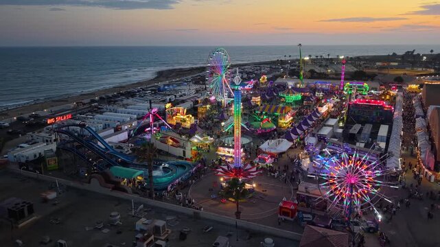 CALIFORNIA - 9.2.2026 - Great aerial footage of the Ventura County Fair's Ferris wheel, log flume, and other rides sitting on the beachfront at sunset.