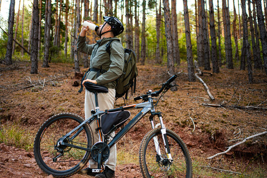 Cyclist enjoying a break in a serene forest on a sunny day