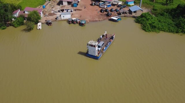 GAMBIA - 12.19.2025 - Very good aerial view of a ferry departing to cross the Gambia River with a van on it.