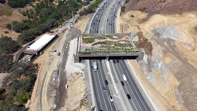 CALIFORNIA - 9.22.2026 - Excellent aerial footage moving into a bird's eye view of the Wallis Annenberg Wildlife Crossing, still under construction, as Highway 101 traffic passes below.