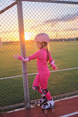 Obraz premium Young girl roller skate outdoor sport park sunset play active childhood