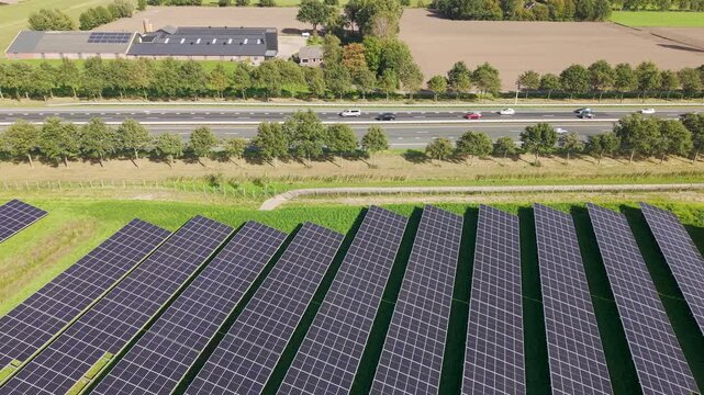 Aerial view of Solar Park with rows of photovoltaic panels next to highway in Ede, Gelderland, Netherlands