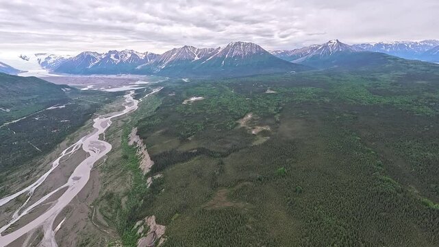 ALASKA - 9.3.2026 - Excellent aerial footage moving over glacier outwash and towards wintry mountains in Alaska's Wrangell-St. Elias National Park and Preserve.