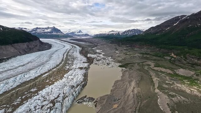 ALASKA - 9.3.2026 - Fantastic aerial footage flying over an icy river near Little Bremner Glacier in Alaska, towards snow-capped mountains.