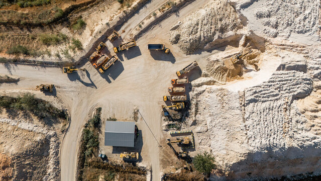 Aerial view of the Besenovo quarry with heavy machinery, excavators, and dump trucks operating in the industrial mining site in Besenovo, Vojvodina, Serbia.