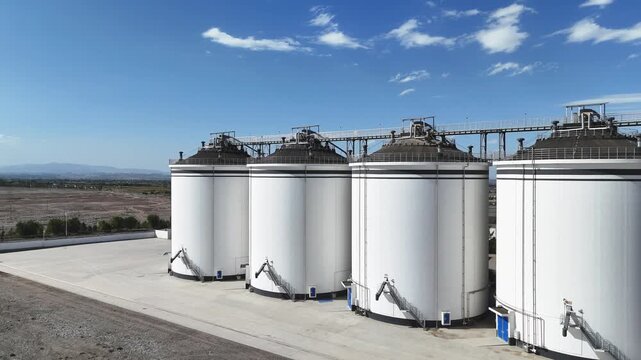 white industrial grain silos under blue sky