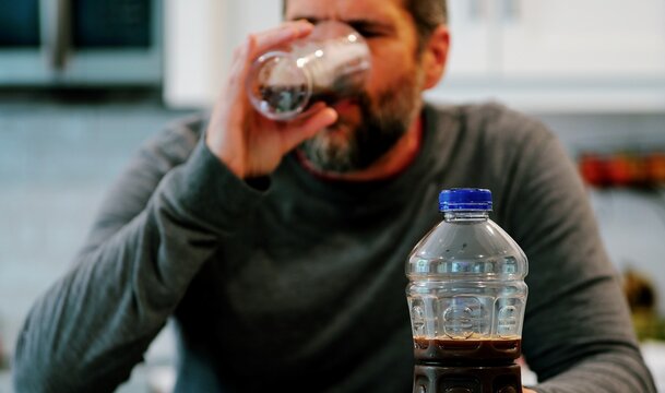 Middle aged man drinking prune juice to aide digestive health naturally - gut health constipation relief remedy aging gracefully preventive wellness
