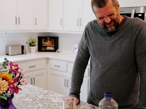 Middle aged man drinking prune juice to aide digestive health naturally - gut health constipation relief remedy aging gracefully preventive wellness