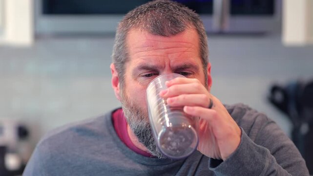 Middle aged man drinking prune juice to aide digestive health naturally - gut health constipation relief remedy aging gracefully preventive wellness