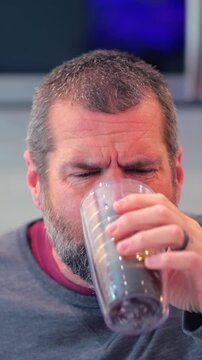 Middle aged man drinking prune juice to aide digestive health naturally - gut health constipation relief remedy aging gracefully preventive wellness
