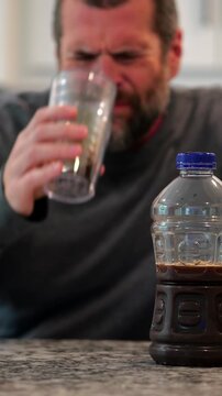 Middle aged man drinking prune juice to aide digestive health naturally - gut health constipation relief remedy aging gracefully preventive wellness