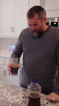 Middle aged man drinking prune juice to aide digestive health naturally - gut health constipation relief remedy aging gracefully preventive wellness