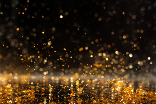 Macro photo of gold glitter sparkles on isolated black background