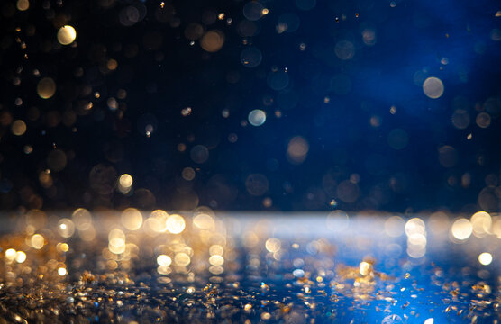 Macro photo of golden glitter particles on neon blue background