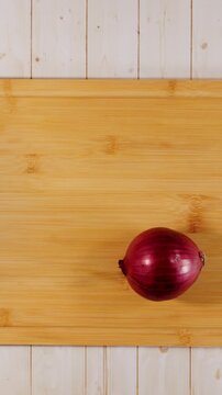 Red Onion Slicing Itself on Cutting Board Flat Lay Stop Motion Animation Vertical Video