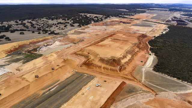 Aerial view of an industrial mining site with exposed sand, earth, and salt deposits, featuring heavy machinery and textured terrain in Kalbarri, Western Australia, Australia.