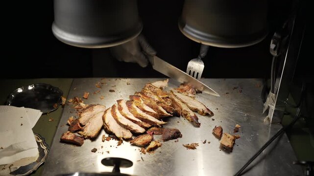 Chef slicing roasted meat at buffet carving station under heat lamps in 4K.   