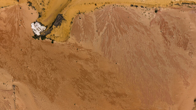 Aerial view of industrial sand and salt patterns with brown and yellow sediment deposits near Useless Loop in Kalbarri, Western Australia, Australia.