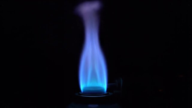 Blue gas flames dancing with subtle motion against a dark backdrop