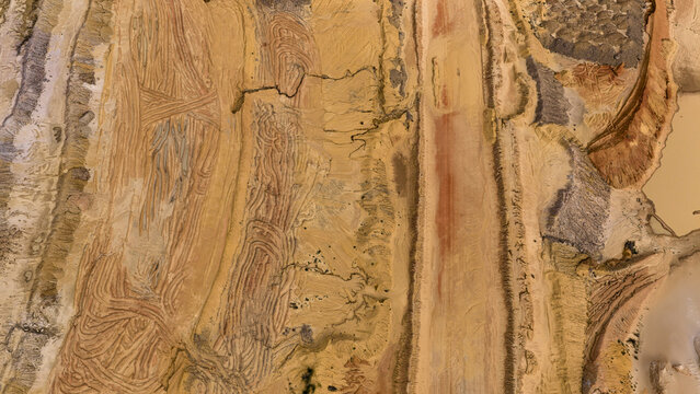 Aerial view of industrial sand and salt patterns at Useless Loop showing textured earth, yellow and brown sediment, and saline deposits in Kalbarri, Western Australia, Australia.