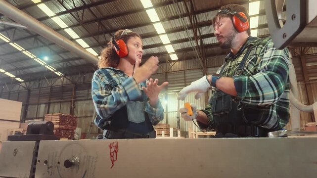 People work together in a warehouse discussing a project while using tools and safety gear