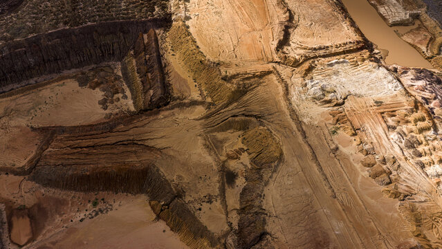Aerial view of industrial sand and salt extraction patterns at Useless Loop, showing brown and yellow earth textures after a storm in Kalbarri, Western Australia, Australia.