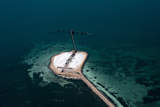 Aerial view of the Useless Loop salt mine facility situated on a small island surrounded by turquoise waters and coral reefs in Kalbarri, Western Australia, Australia.