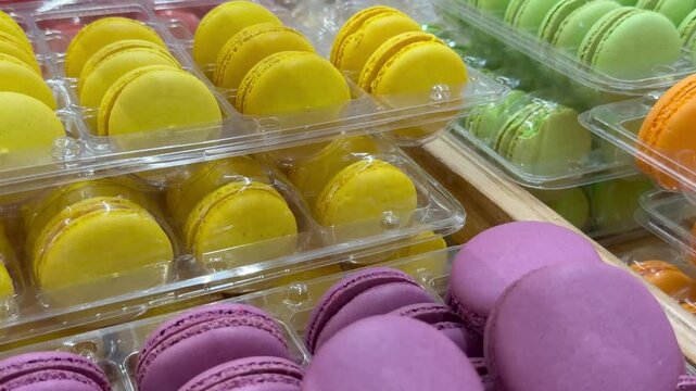 Colorful macarons neatly arranged in clear plastic packaging, presenting an appealing dessert display for bakery and confectionery marketing concepts.