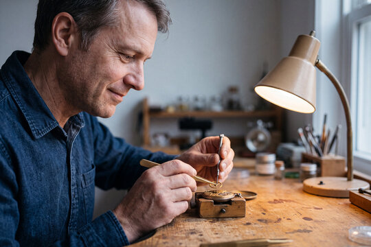 Watchmaker repairing a vintage timepiece at his workbench
