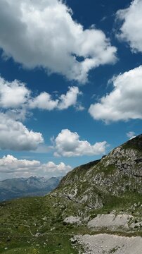 Vertical panorama shows rocky green slopes of Sedlo Pass in Durmitor Montenegro. Alpine summer scenery for hiking tourism adventure and travel