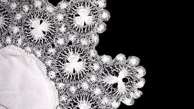 Tenerife lace, needle lace antique traditional doily also known as Spanish Sol Lace embroidery, whitework, white work, needlework. Isolated on black background, border art design, top view, vintage