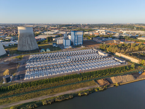 Aerial view of the Cargovil battery energy storage system with rows of battery containers, cooling towers, and industrial buildings situated along a canal in Vilvoorde, Vlaanderen, Belgium.