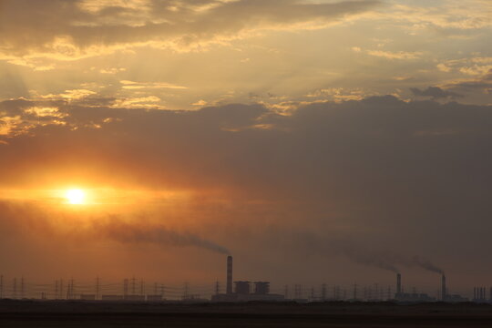 Factory with smokestacks at sunset. smokestacks contributing to the pollution in the air