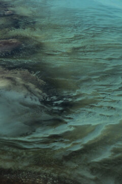Aerial view of intricate ocean patterns and turquoise waters in the Shark Bay marine environment, showcasing natural sediment formations in Shire of Shark Bay, Western Australia, Australia.