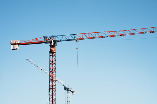 Red tower construction crane against a clear blue sky