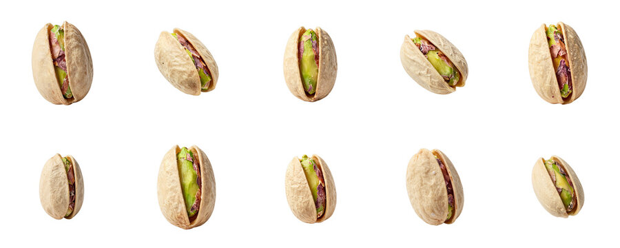 Scattered pistachios in various angles displayed on a black backdrop in a studio setting
