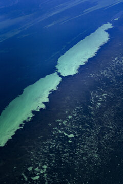 Aerial view of turquoise ocean patterns and coral reefs in the shallow waters of the Indian Ocean in Shire of Shark Bay, Western Australia, Australia.