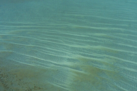 Aerial view of intricate sand patterns on the shallow turquoise ocean floor in the Shire of Shark Bay, Western Australia, Australia.