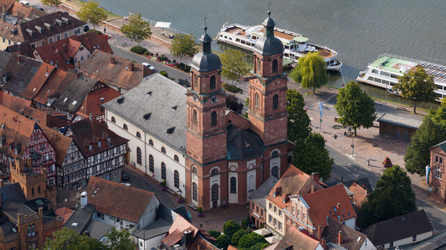 Aerial view of Stadtpfarrkirche St. Jakobus surrounded by historic half-timbered houses and the Main river in Miltenberg, Bayern, Germany.