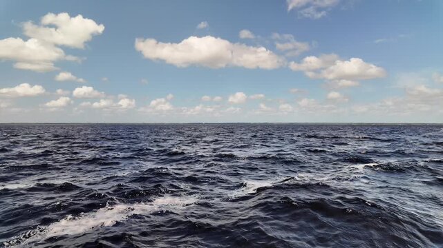 Slow Motion Waves on Lake Monroe Under Blue Sky and Clouds in Florida