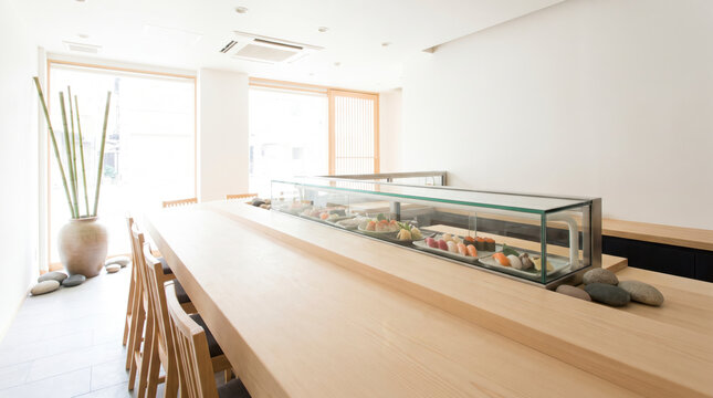 Serene minimalist sushi restaurant interior with wooden counter and display case