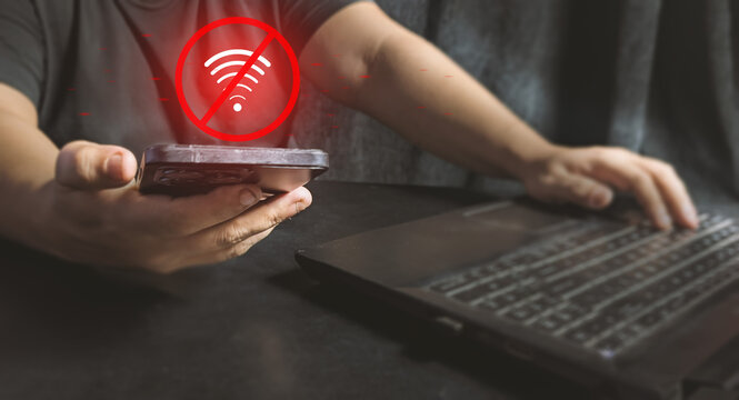 Man holding a smartphone with a red no Wi-Fi icon, illustrating an internet connection error, network outage, and disrupted digital communication
